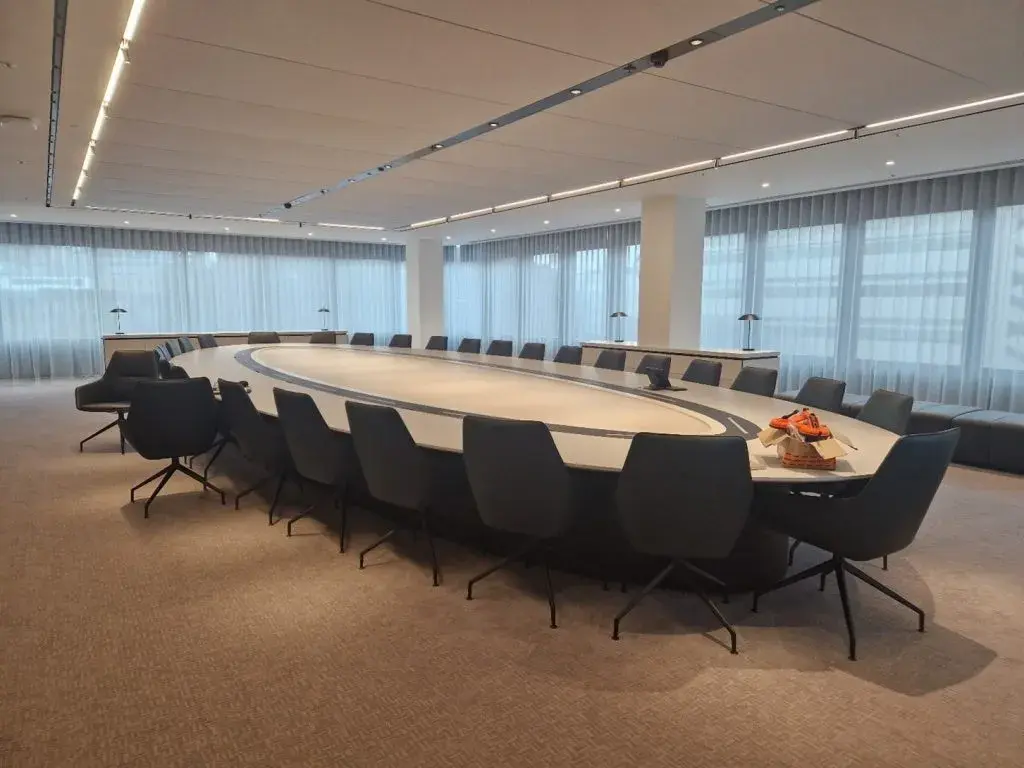 A boardroom table fully maintained by Ability International surrounded by chairs and in the middle of a boardroom belonging to a client.