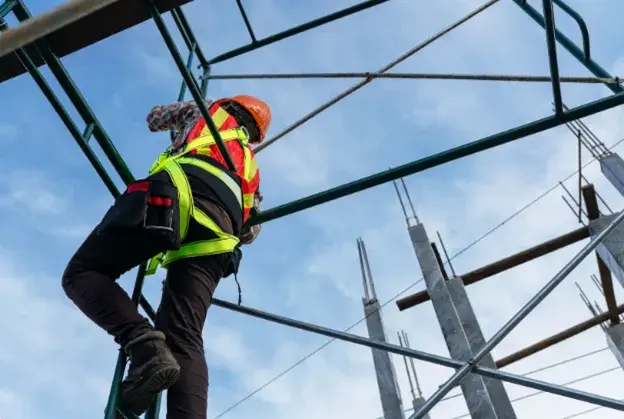 Construction worker climbing scaffolding and committing a height safety violation whilst working at height.