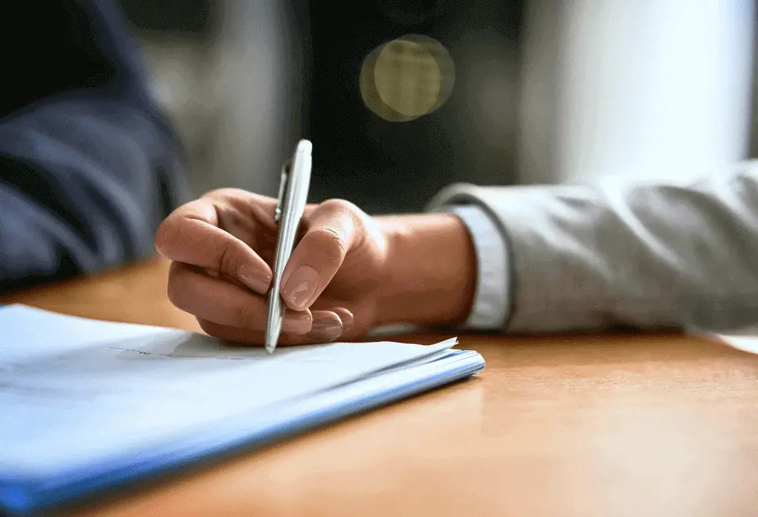 A contractor signing a cheque for a fine that they have received as a result of a fall.