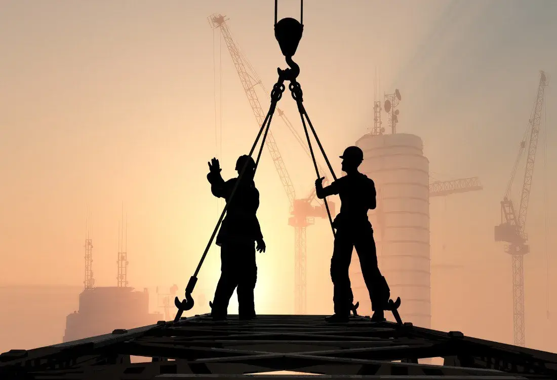 Two silhouettes of people working at height and the sun rising in the horizon.