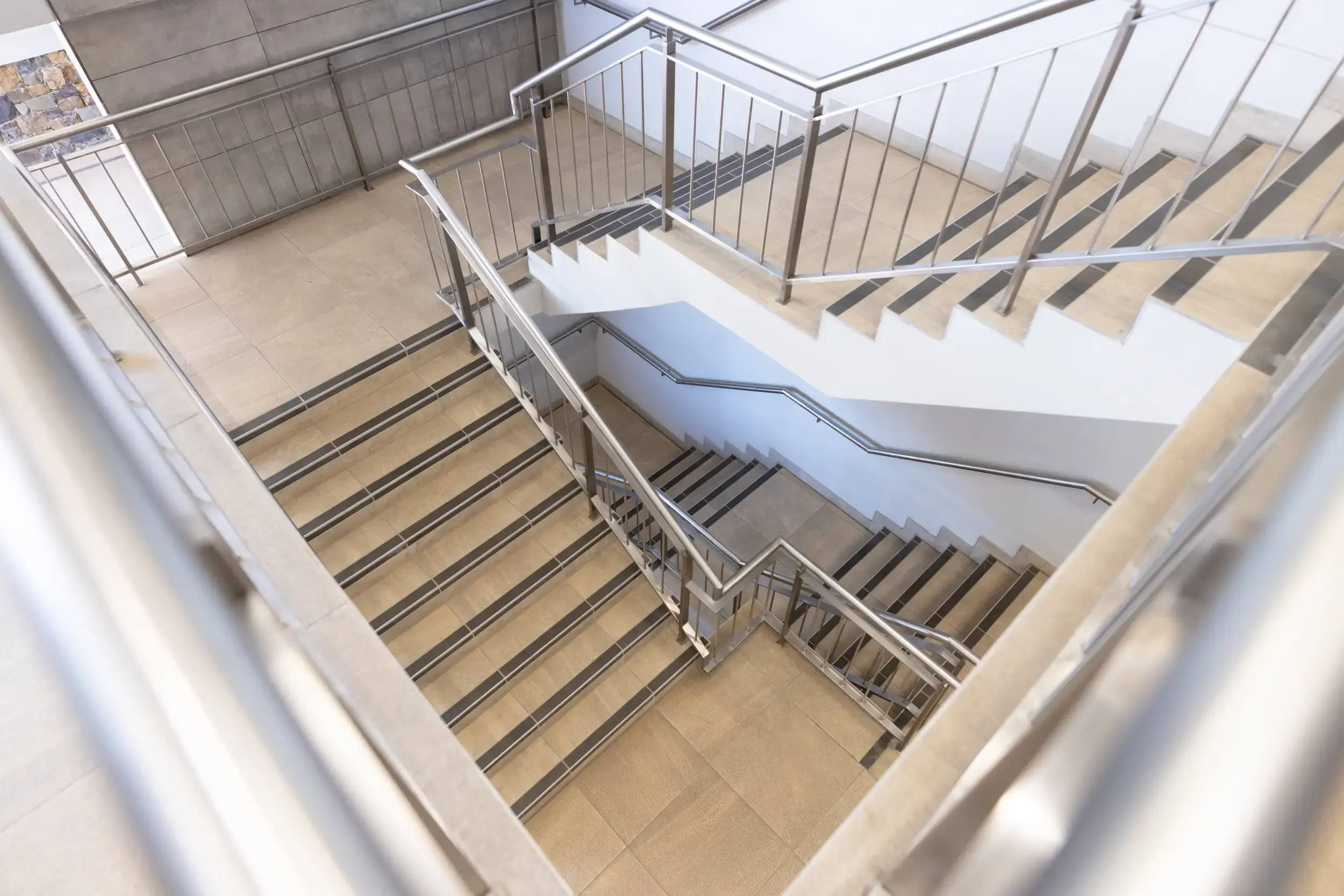 Multi-level staircase in a modern corporate building, the type of environment where DeskSurfer stair compatibility is an important consideration for installation.