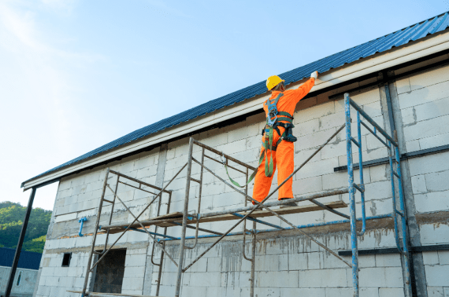 Workman on a scaffolding platform during a busy April at Ability International.