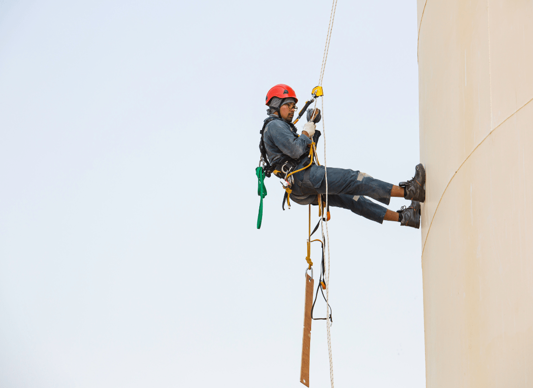 Male worker using rope access for industrial tasks at height which emphasises the importance of proper training and following instructions for safety.