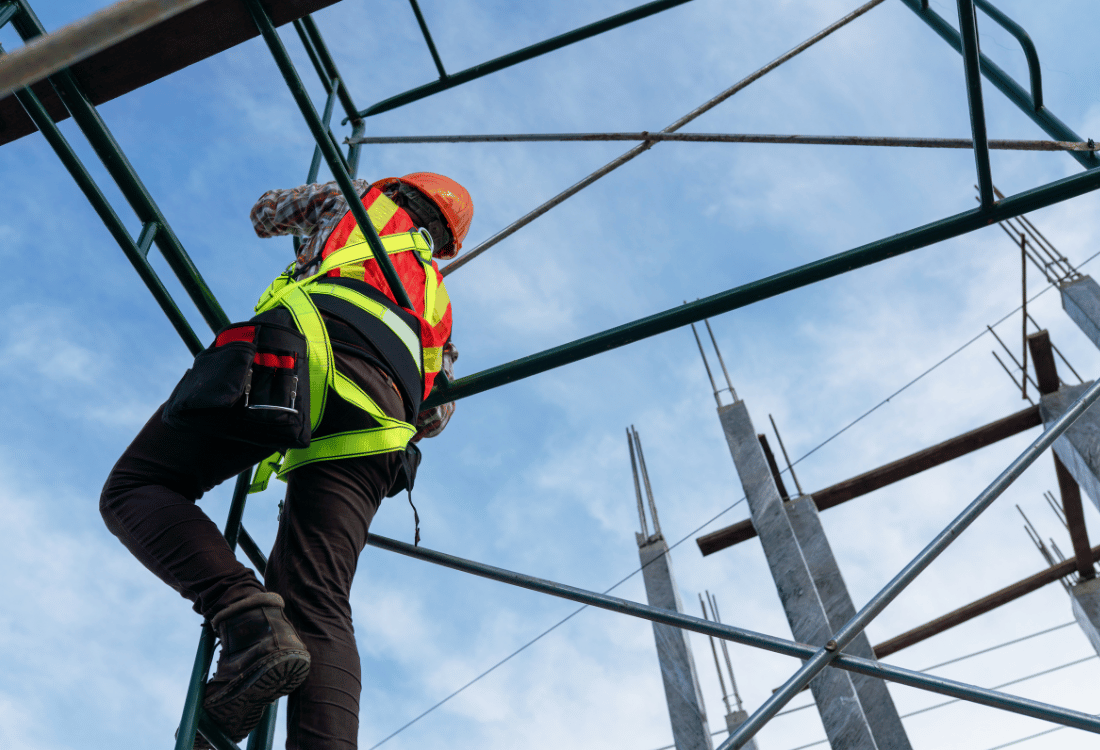 A person working at height while wearing a safety harness.